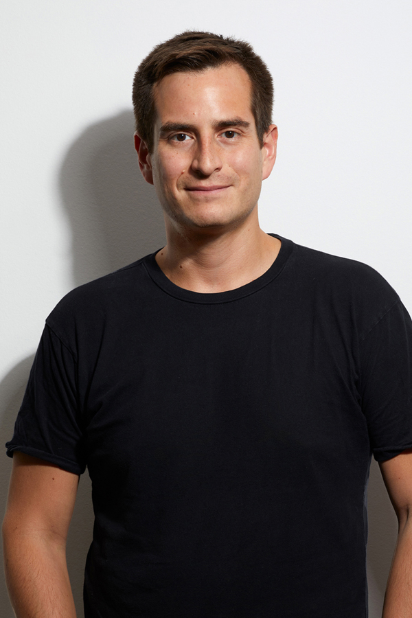 Employee photo of Ernesto Oyarbide-Magaña. He wears a black T-shirt and stands in front of a white wall.